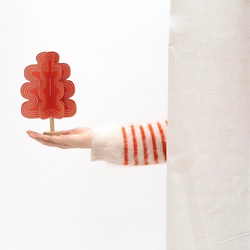 Hånd som holder rødt juletre