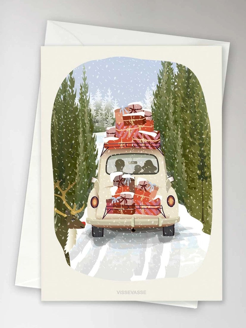 hvit bil med julegaver på taket i vinterlandskap