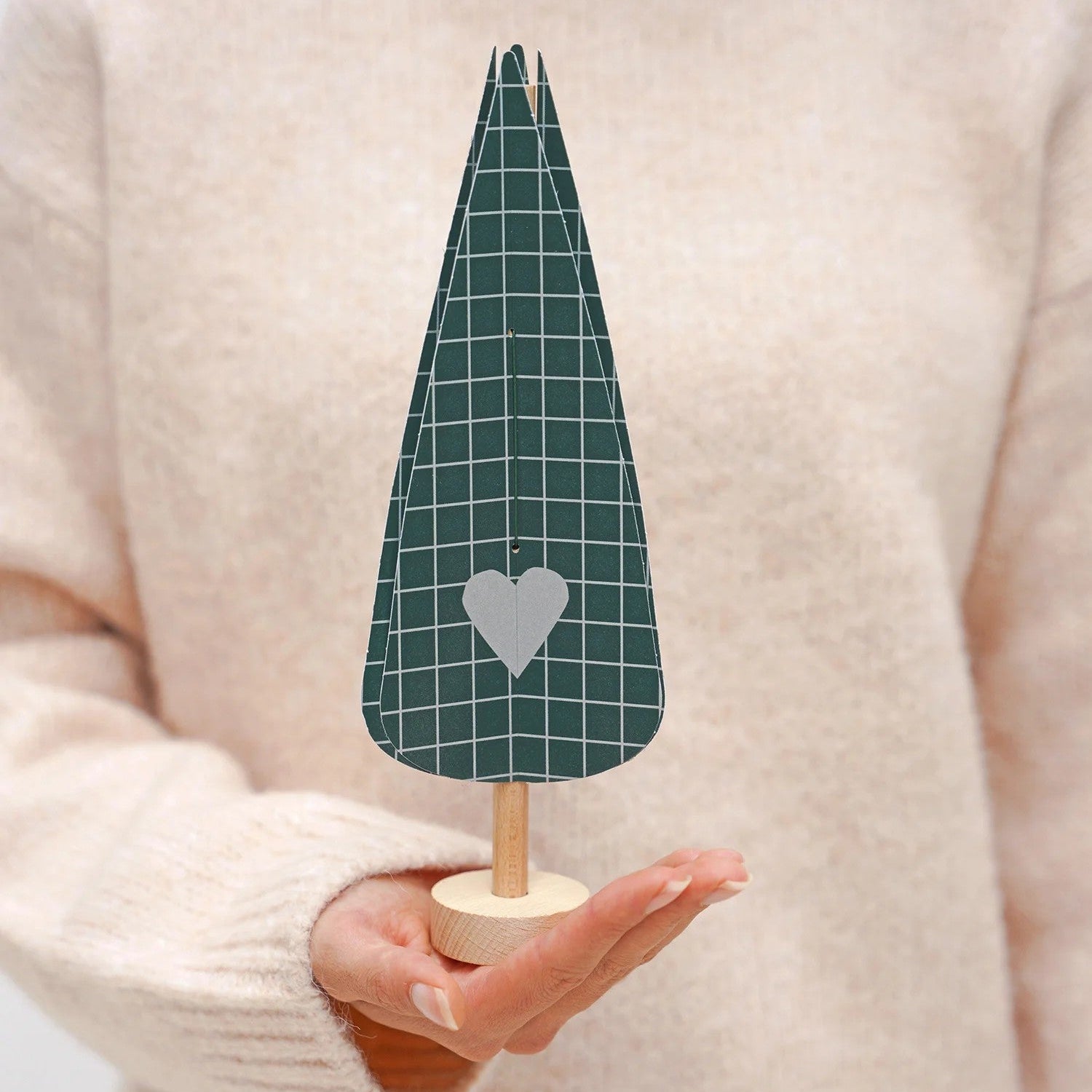 hånd som holder et juletre i papir